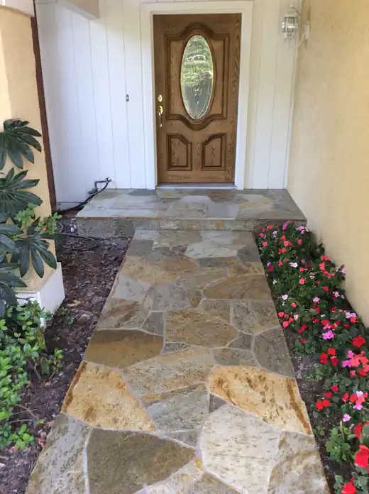 Flagstone entry path running between plantings to a front door