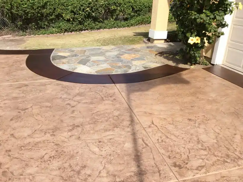 Stamped concrete patio with a flagstone-look medallion inside a dark stained band