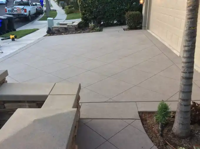 Patio slab scored in a diagonal grid against a stucco house