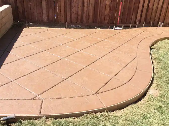 Terracotta concrete patio with diagonal score lines and a curved edge