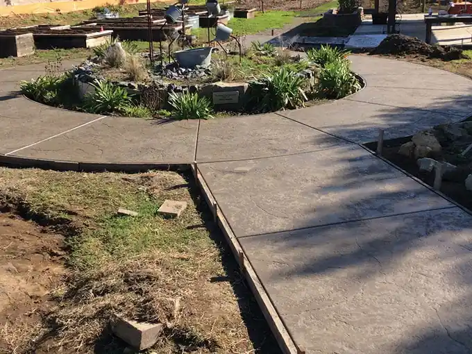 Curved concrete patio ring around a planted bed