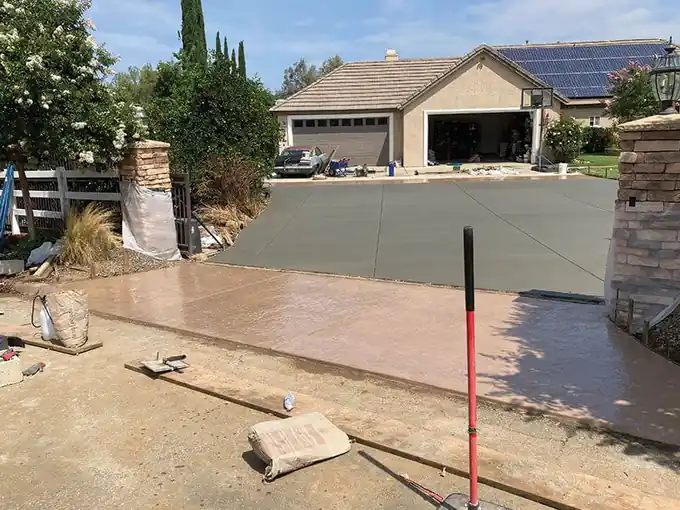 New concrete slab with a terracotta stamped apron, wooden forms still in place