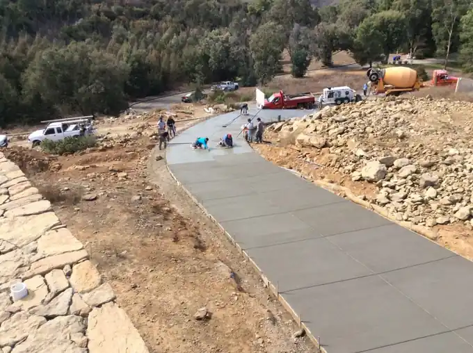 Long finished concrete walkway winding along a hillside property